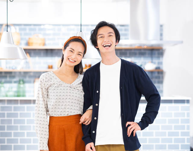 笑顔で腕を組む男女