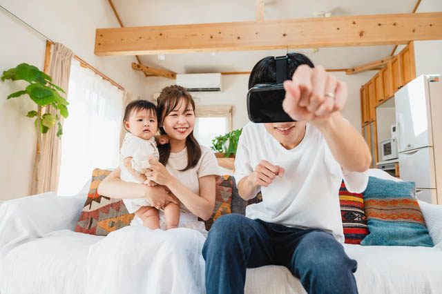 VRゴーグルをしている夫とそれを見守る子供と妻